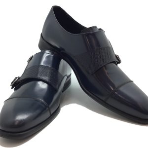 Zapato modelo Oxford, con cierre en hebilla doble y corte en puntera.