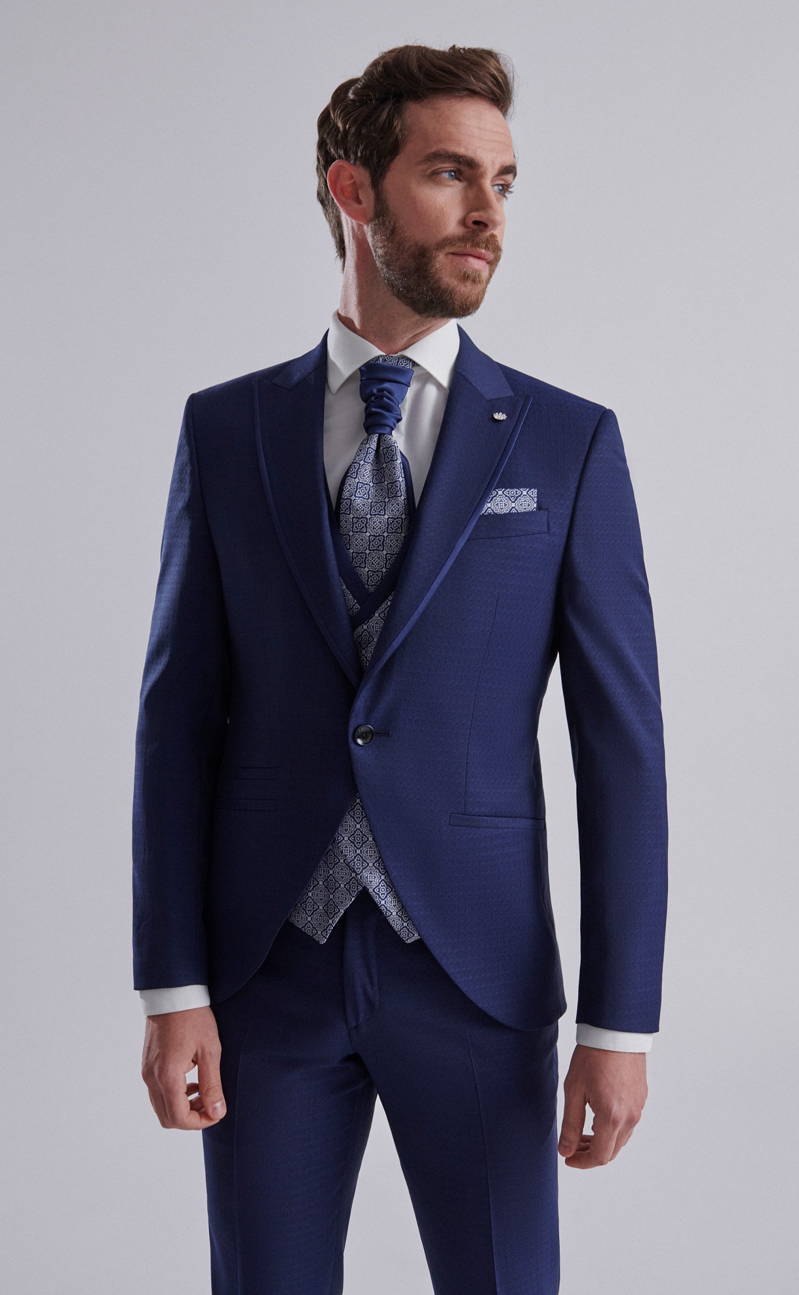 Traje de novio con tejido labrado y vivos en raso en color azul marino con chaleco cruzado y falsa solapa de la Colección Trend.