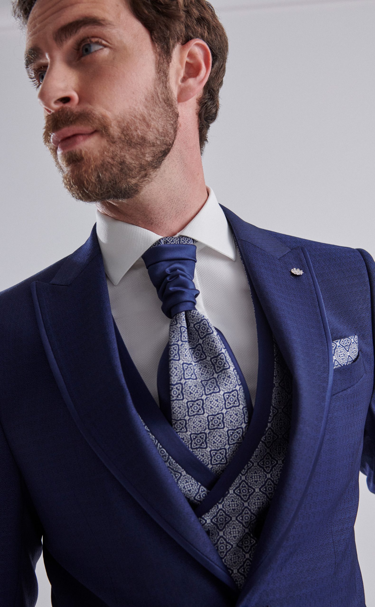 Traje de novio con tejido labrado y vivos en raso en color azul marino con chaleco cruzado y falsa solapa de la Colección Trend.