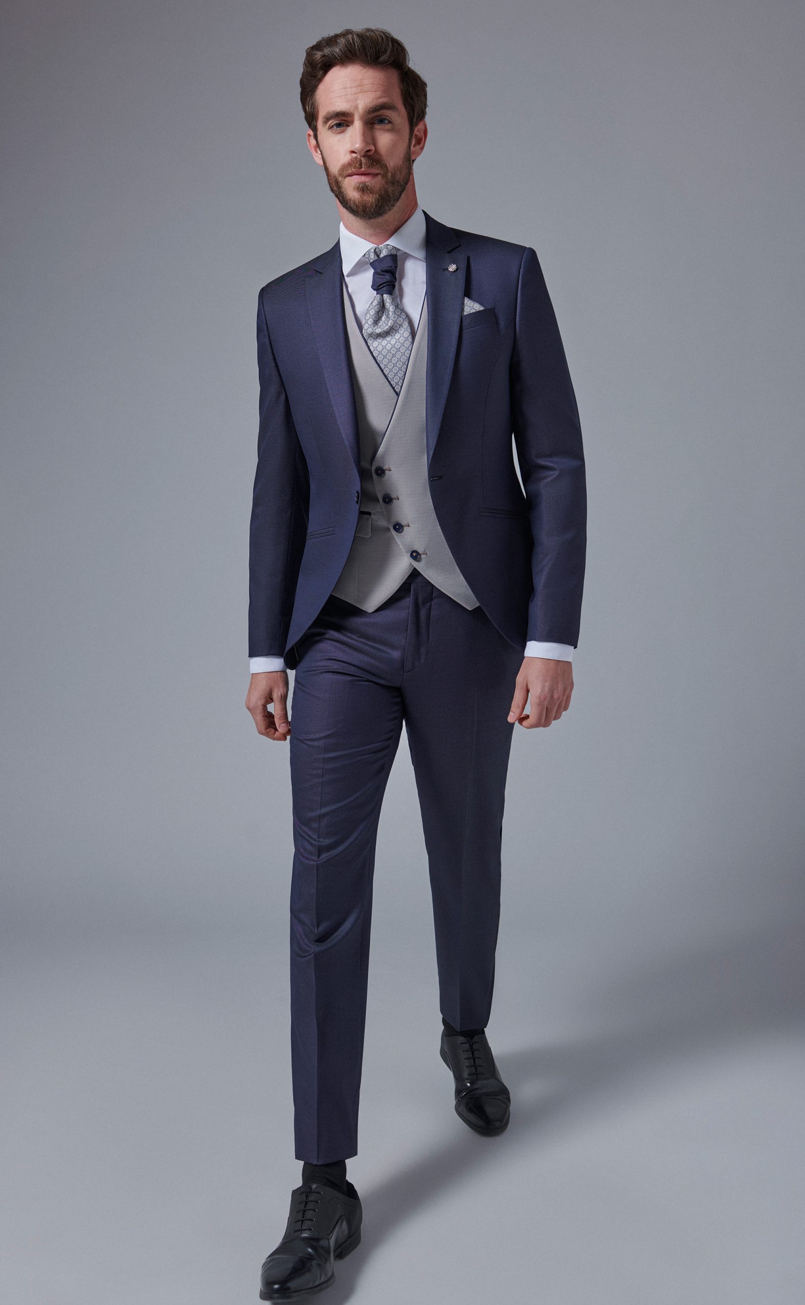 Traje de novio en color azul marino con chaleco gris plata liso de la Colección Trend.